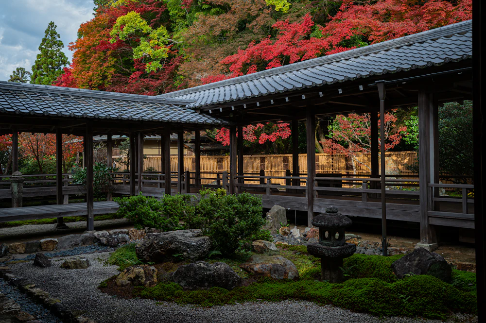 Puente cubierto de madera entre arces rojos en un templo de Kioto, en otoño