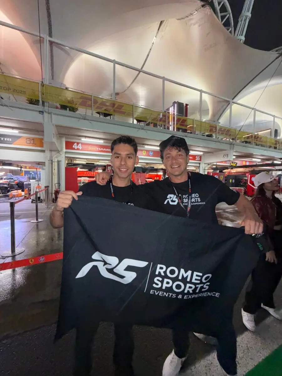 Viajeros de Romeo Sports con la bandera de la marca en el paddock de Interlagos